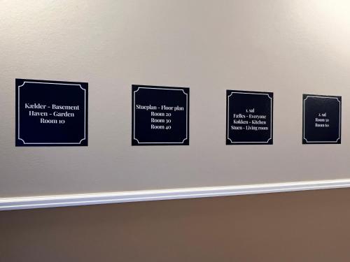 a wall with four black signs on a wall at Byhuset - Penthouse in Vejle