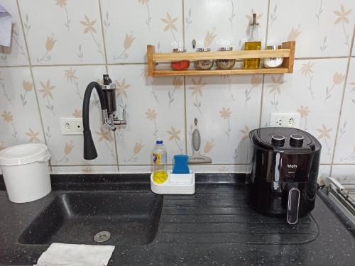 a kitchen counter with a sink and a coffee maker at Apartamento 4 ótima localização Alumínio in Aluminio
