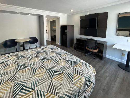 a hotel room with a bed and a flat screen tv at Motel 6 Buena Park, CA Anaheim Near Maingate Knotts in Buena Park