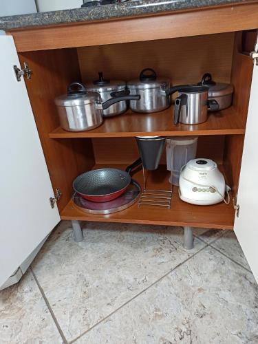 a shelf with pots and pans and other kitchen utensils at Apartamento 4 ótima localização Alumínio in Aluminio