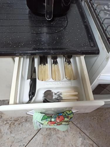 a drawer in an oven with utensils in it at Apartamento 4 ótima localização Alumínio in Aluminio