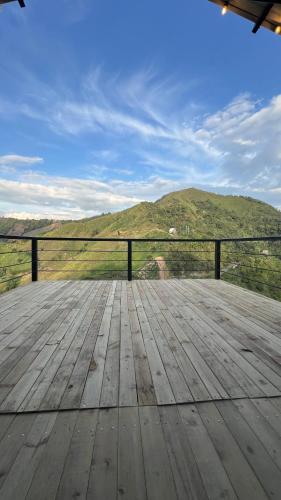 a wooden deck with a view of a mountain at La Peña Cabins - Ebéjico in Ebéjico