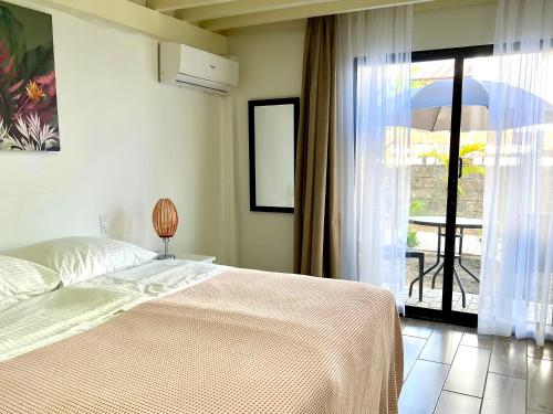a bedroom with a bed and a large window at Villa Famiri Boutique hotel in Paramaribo