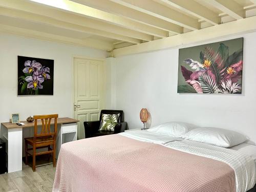 a bedroom with a bed and a desk and a table and chairs at Villa Famiri Boutique hotel in Paramaribo