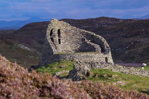 an old stone building on the side of a hill at Carloway Self Catering, 5A Upper Carloway, Isle of Lewis, Outer Hebrides in Carloway