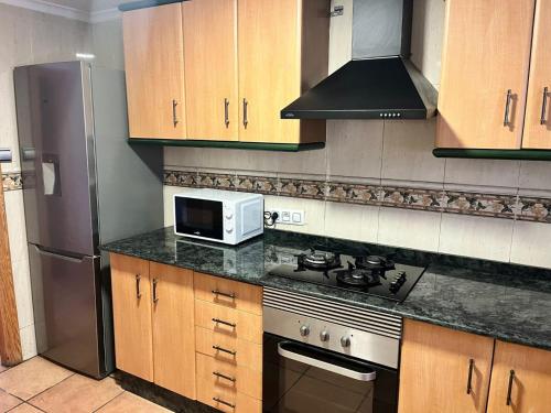 a kitchen with a stove and a microwave at Villas de encanto in Vilamarxant