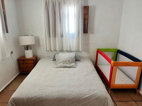 a small bedroom with a bed and a chair at Villas de encanto in Vilamarxant