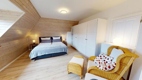ein Schlafzimmer mit einem Bett und Stühlen in einem Zimmer in der Unterkunft Ferienhaus Knippschild in Norderney