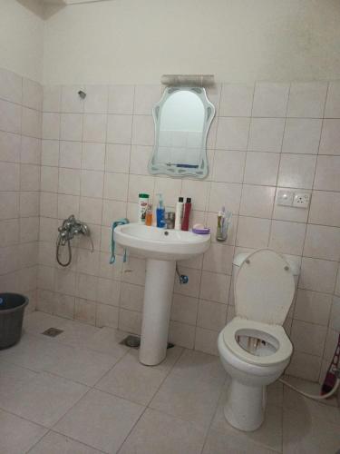 a bathroom with a toilet and a sink at A house where you feel like home in Islamabad