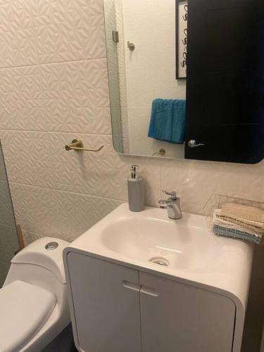 a bathroom with a white sink and a toilet at Casa de lujo a 7min de consulado in Ciudad Juárez