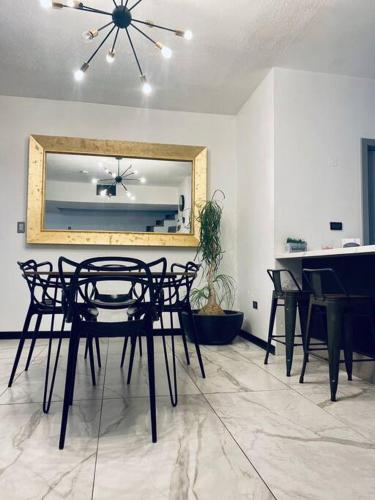 a dining room with a table and chairs and a mirror at Casa de lujo a 7min de consulado in Ciudad Juárez