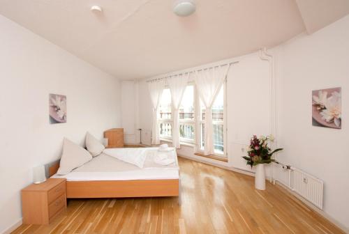 a white room with a bed and a large window at Apartments am Brandenburger Tor in Berlin