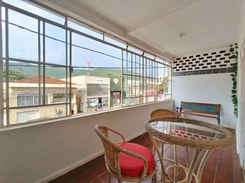 a room with a table and chairs and a large window at Casa Espaçosa em Poços de Caldas SPL0342 in Poços de Caldas