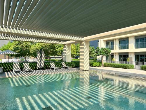 a swimming pool with chairs under a pergola at Burj Royale - Luxury Stay with Panoramic Burj Khalifa & Fountain View in Dubai