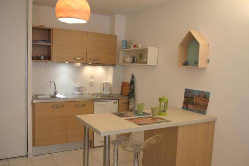 une cuisine avec des armoires en bois et un comptoir blanc dans l'établissement Le 7 Augustin, à Nice