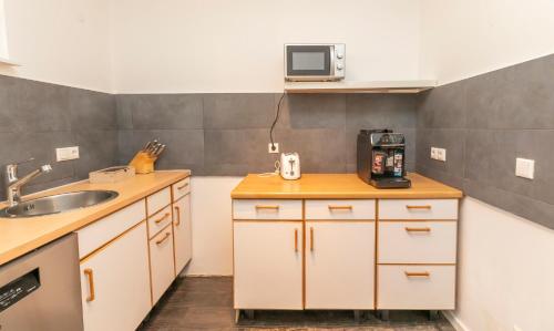 a small kitchen with a sink and a microwave at Ein Familie Haus in Zentrale Lage in Dreieich