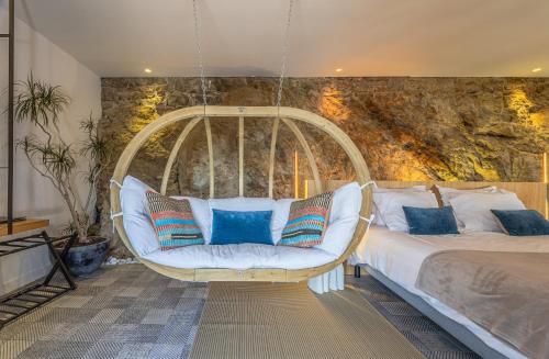 a swing in a bedroom with a bed and blue pillows at Restaurant Hotel Didier Méril in Dinard