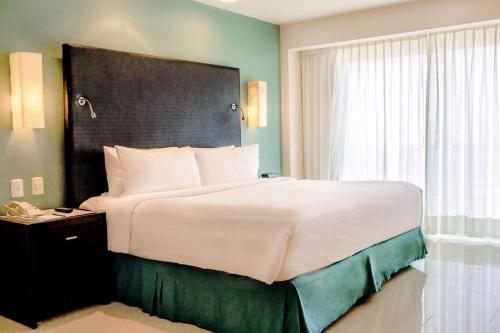 a bedroom with a large bed and a window at Emporio Veracruz in Veracruz