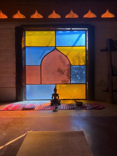 a stained glass window in a room with a rug at Shanti - Hospedagem e Vivências Terapêuticas in Sao Jorge