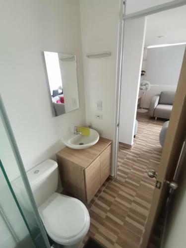 a bathroom with a sink and a toilet and a mirror at Apartamento Ibagué in Ibagué