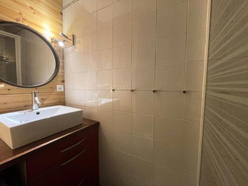 une salle de bain avec un lavabo et un miroir dans l'établissement Résidence Rochail - Duplex chaleureux en centre station avec vue sur les pistes MAE-5311, à Vénosc
