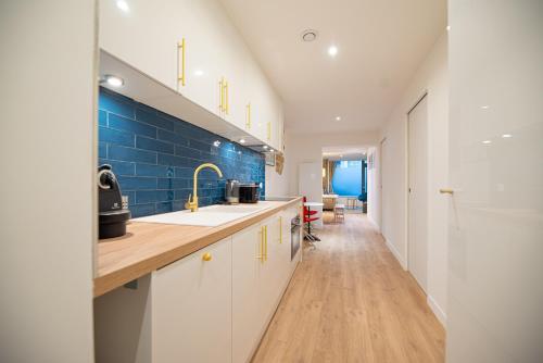 Il comprend une cuisine avec un évier et un mur en carrelage bleu. dans l'établissement Beautiful Apartment in Saint Germain, à Paris