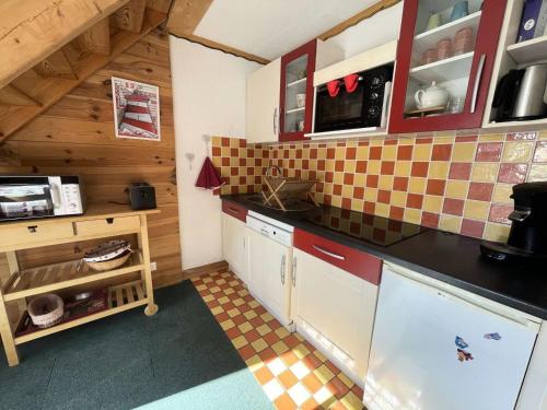 une cuisine avec un comptoir noir dans une pièce dans l'établissement Résidence Rochail - Duplex chaleureux en centre station avec vue sur les pistes MAE-5311, à Vénosc