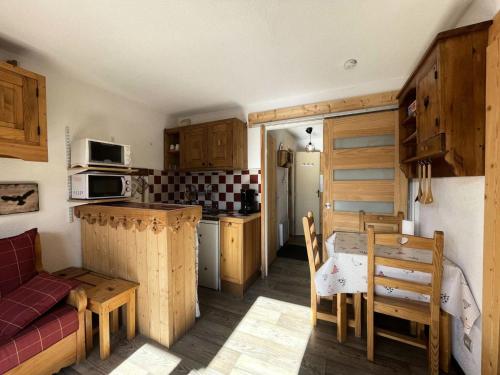 une cuisine avec des armoires en bois et une table et des chaises dans l'établissement Résidence Pleiades - Appartement style montagne avec vue dégagée sur la station et les montagnes dans un secteur calme MAE-5571, à Vénosc