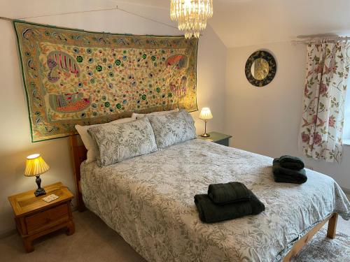a bedroom with a bed with a large tapestry on the wall at The Linhay in Minehead