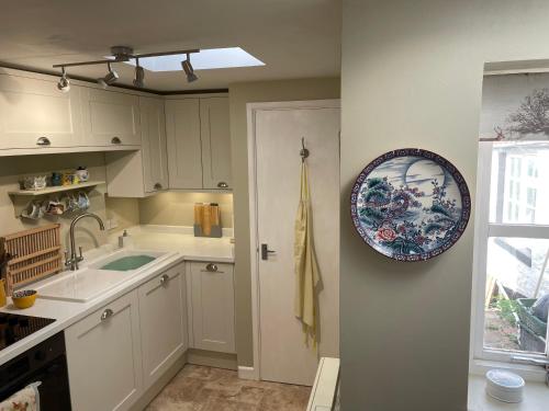 a kitchen with a sink and a plate on the wall at The Linhay in Minehead