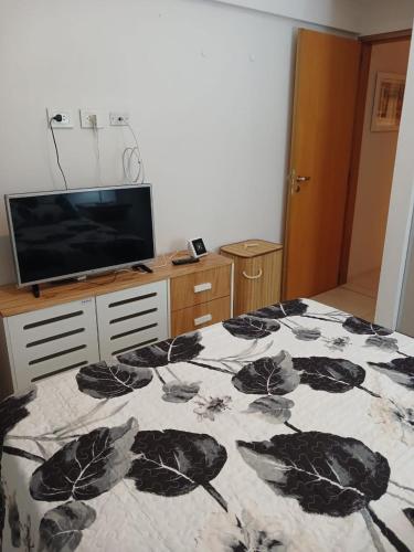 a bedroom with a bed with a leaf pattern on it at CASA FRAN Departamento temporal in Luján