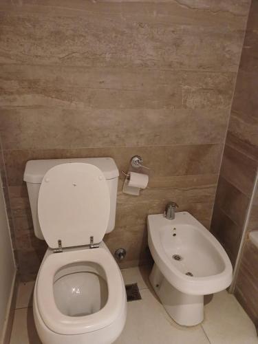 a bathroom with a white toilet and a sink at CASA FRAN Departamento temporal in Luján
