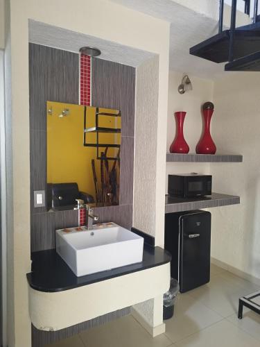 a bathroom with a white sink and red vases at HOTEL MORELOS in Guadalajara