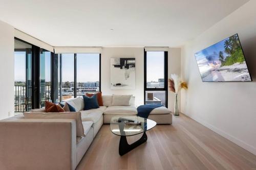 a living room with a couch and a glass table at The Rose Quartz - Rooftop Pool, Gym Glamorous Santa Monica 2BR in Los Angeles