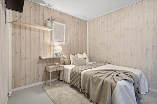 a bedroom with a bed and a table with a lamp at Historisk hus i hjertet av byen in Bergen