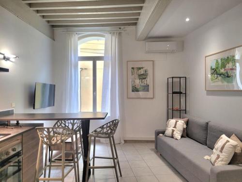 un salon avec un canapé, une table et des chaises dans l'établissement Appartement Au cœur de l'Isle, à LʼIsle-sur-la-Sorgue