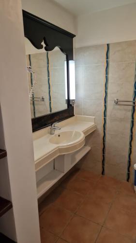 a bathroom with a sink and a mirror at AYOUNAKA, Appartement cosy avec plage terrasse & piscine in Courcelles Sucrerie