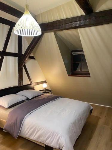 une chambre avec un grand lit dans un grenier dans l'établissement À la petite Venise hyper centre Colmar, à Colmar