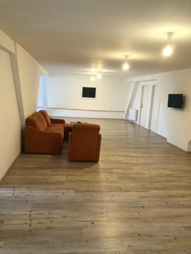 an empty living room with two couches and a television at Apartment Krasniqi in Hönigsberg