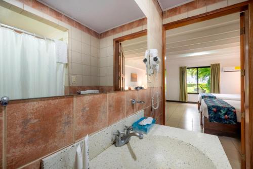 a bathroom with a sink and a mirror at Jaco Laguna Resort & Beach Club in Jacó