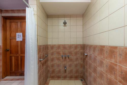 a bathroom with a shower with brown tile at Jaco Laguna Resort & Beach Club in Jacó