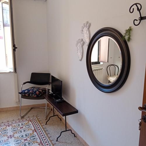 a room with a mirror and a chair and a table at Happy Holiday in Palazzolo Acreide