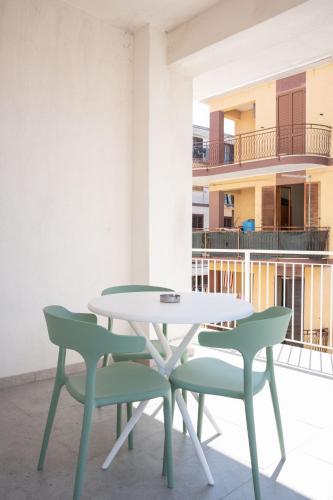 a table and two chairs on a balcony at Ambrosia Room & Apartment in Rossano