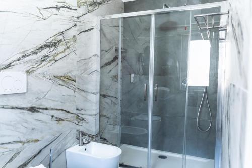 a bathroom with a shower and a toilet and a sink at Ambrosia Room & Apartment in Rossano