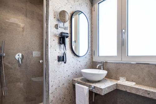 a bathroom with a sink and a shower at Ambrosia Room & Apartment in Rossano