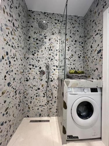 a bathroom with a shower and a washing machine at City Center Urban Condo in Tirana
