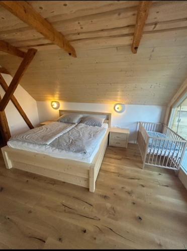 a bedroom with a bed in a wooden attic at Gorjuška Rozamunda in Bohinjska Bistrica