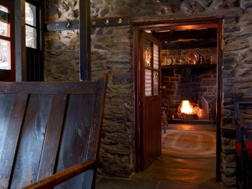 an open door to a room with a fireplace at Y Talbot in Tregaron