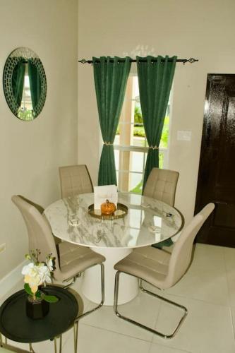 a dining room with a glass table and chairs at Paradise in Edgehill, Jamaica! in St Mary