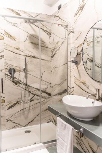 a bathroom with a sink and a shower at Ambrosia Room & Apartment in Rossano